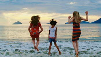 children_jumping_in_mid_air_by_sea